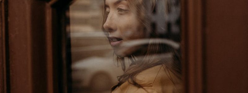 Close up of a person looking out of a window.