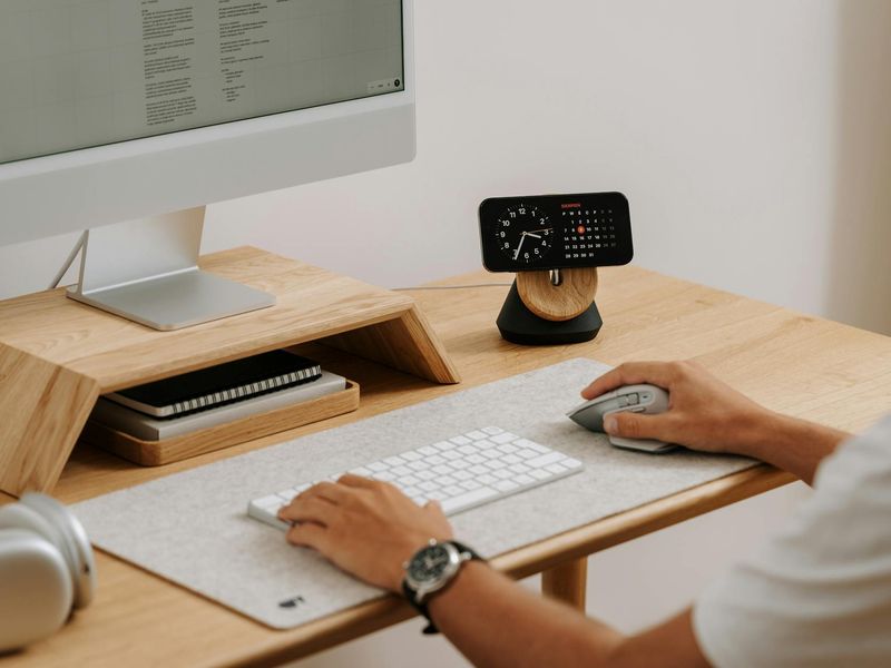 Modern clean office desk with plants and soft lighting.
